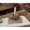 This is a yule log centerpiece with a snowy pine and red berry arrangement. It holds a battery-operated candy cane candle. 